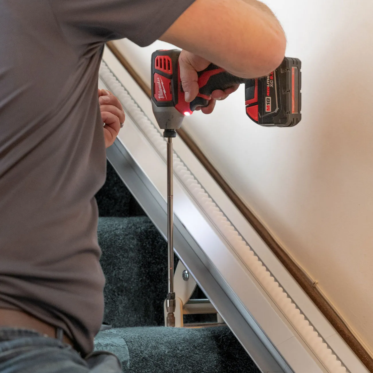 Leaf Home Safety solutions employee installing a stair-lift rail system
