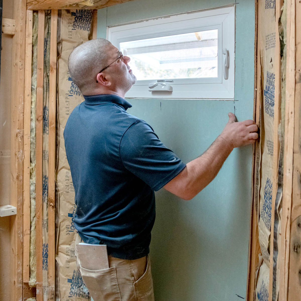 Leaf Home Safety Solutions employee installing drywall around an adjustable window